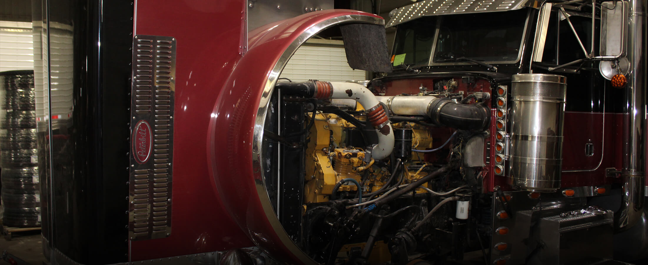 Engine cover of a semi tractor pulled back showing the diesel engine